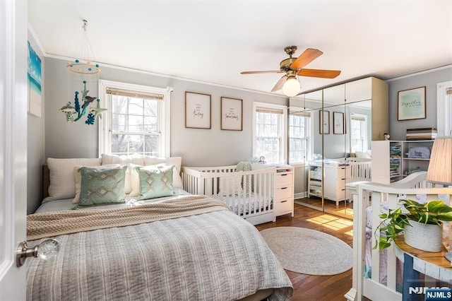 bedroom featuring a ceiling fan, crown molding, and wood finished floors