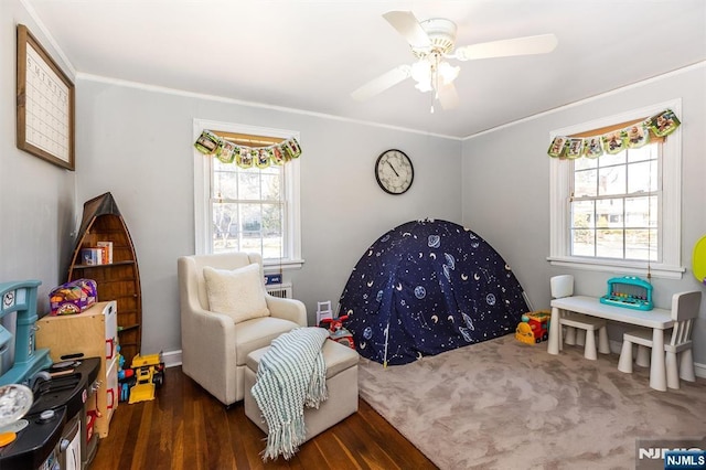 bedroom with ornamental molding, a ceiling fan, multiple windows, and wood finished floors