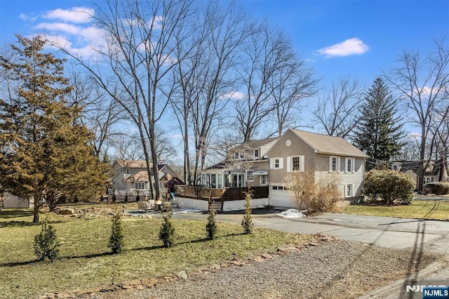 view of front of home with a garage, driveway, and a front lawn