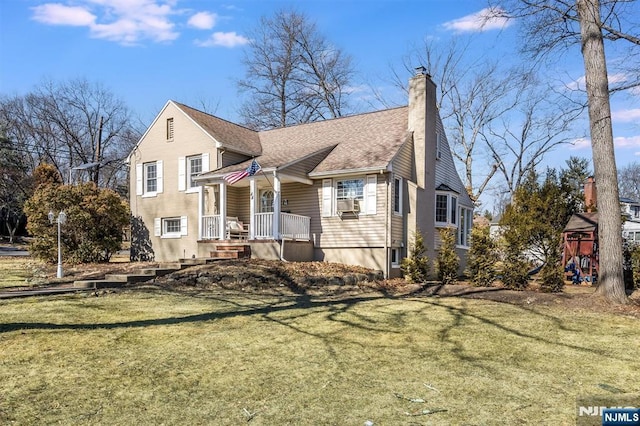 view of front facade with a playground, a shingled roof, a chimney, and a front yard