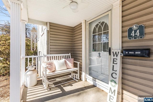 entrance to property with a porch and a ceiling fan