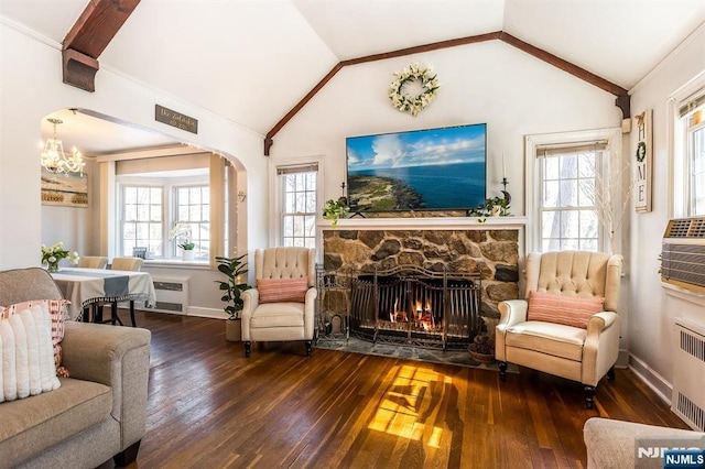 living area with a healthy amount of sunlight, vaulted ceiling, and hardwood / wood-style floors