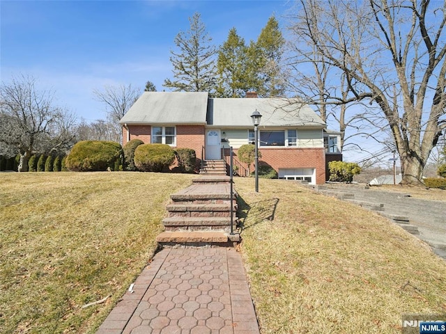 view of front of property featuring a garage, a front yard, brick siding, and a chimney