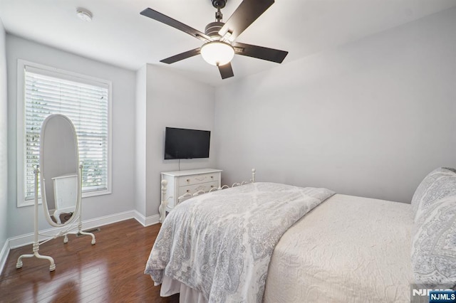 bedroom with a ceiling fan, baseboards, and wood finished floors