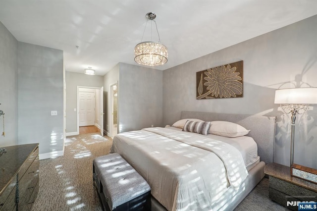 bedroom featuring an inviting chandelier and baseboards