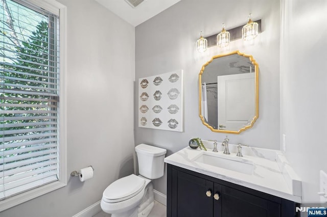 bathroom with baseboards, vanity, and toilet