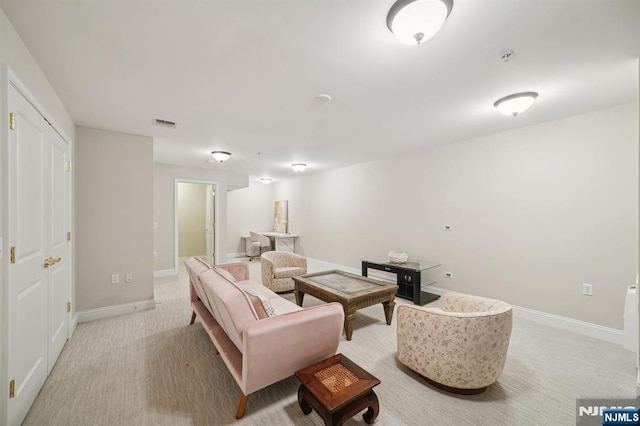 living area with visible vents, light carpet, and baseboards