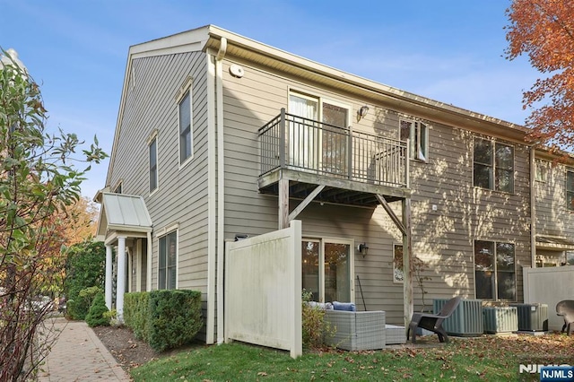 rear view of property with central AC and a balcony