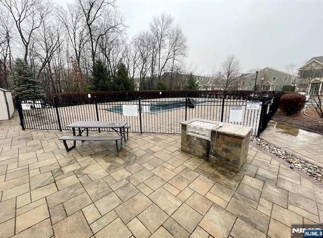 view of patio / terrace featuring fence and a community pool