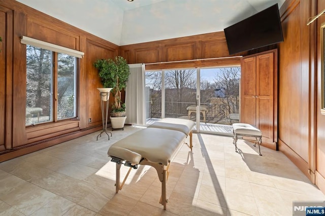 living area with wooden walls and a high ceiling