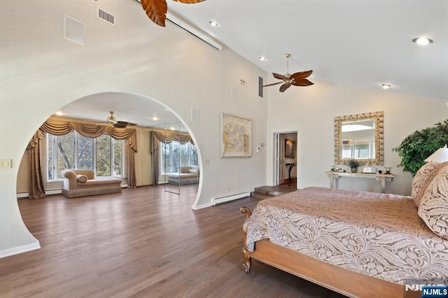 bedroom featuring arched walkways, wood finished floors, visible vents, baseboards, and baseboard heating