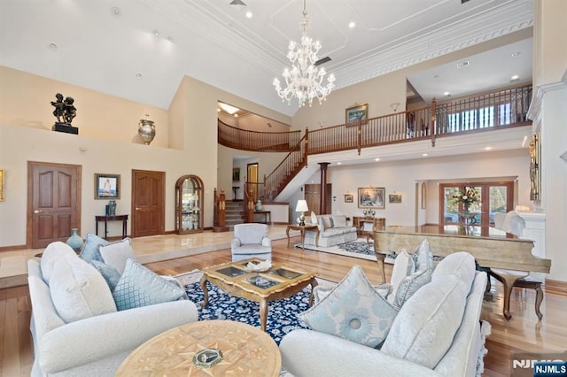 living room featuring stairs, ornamental molding, a notable chandelier, and wood finished floors