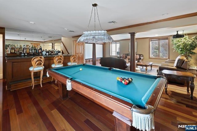 playroom with dark wood-style flooring, visible vents, a bar, decorative columns, and crown molding