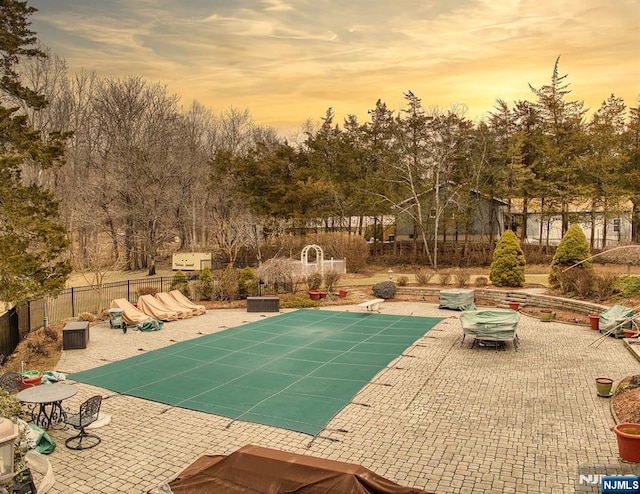 view of swimming pool featuring a patio area and fence