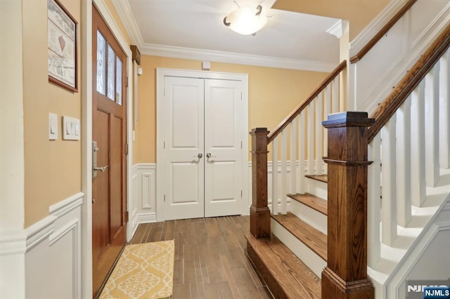 entryway with stairs, dark wood-type flooring, and crown molding