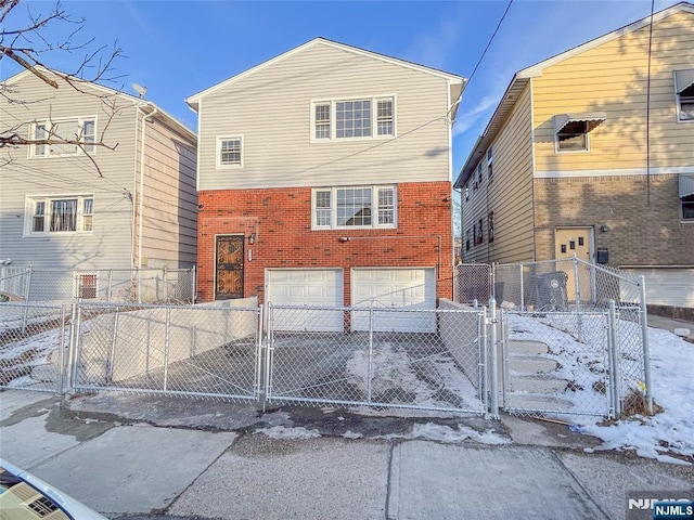 exterior space featuring a gate, brick siding, and an attached garage