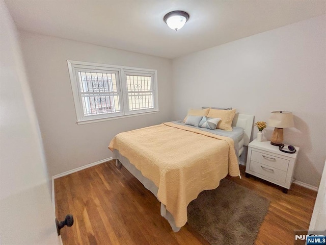 bedroom featuring baseboards and wood finished floors