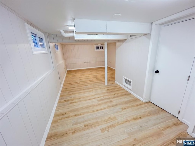 basement featuring light wood-type flooring and visible vents