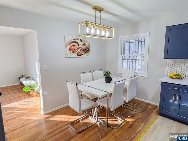 dining room with light wood-type flooring and baseboards