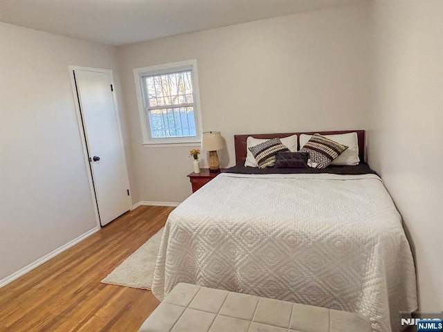 bedroom featuring baseboards and wood finished floors