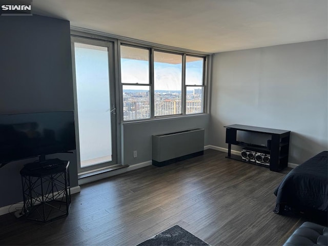 bedroom featuring radiator heating unit, baseboards, and wood finished floors