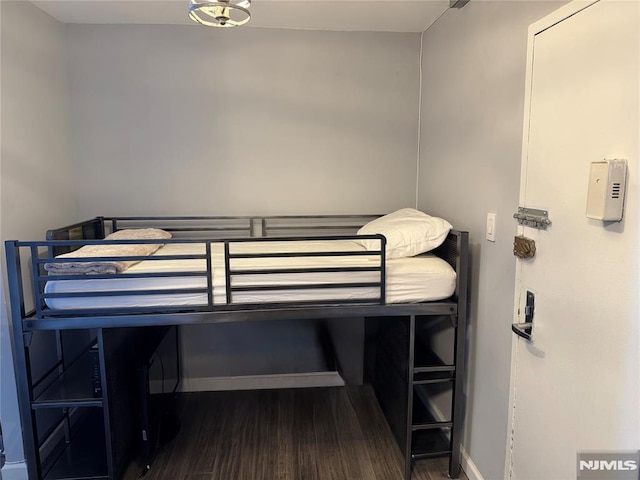 bedroom featuring baseboards and wood finished floors