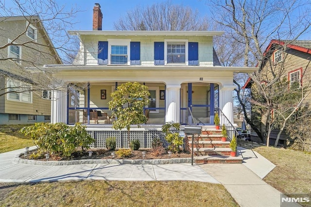 view of front of home featuring covered porch and a chimney