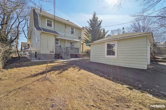 back of property with an outbuilding and fence