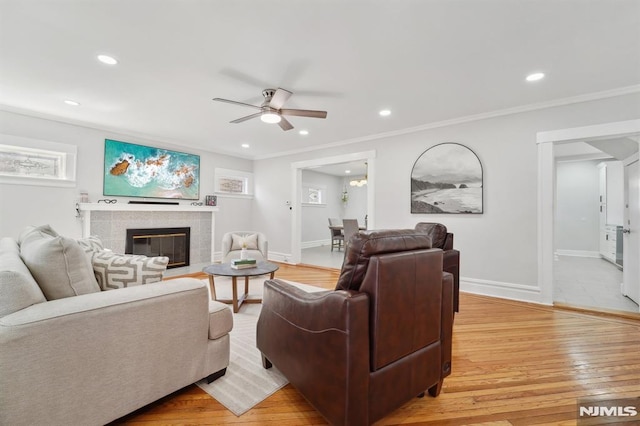 living room featuring light wood-style floors, a fireplace, and baseboards