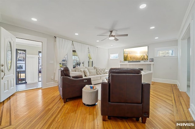 living room with baseboards, ornamental molding, light wood-style flooring, and recessed lighting