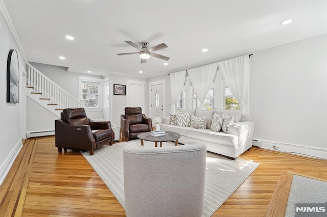 living room featuring recessed lighting, stairway, light wood-style flooring, a baseboard heating unit, and ceiling fan