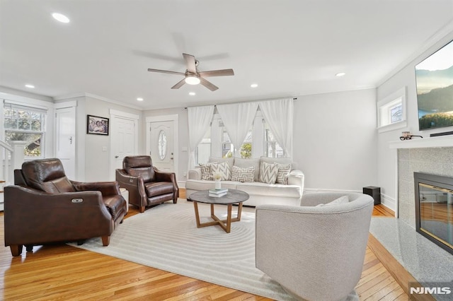 living room with light wood finished floors, a fireplace, and recessed lighting