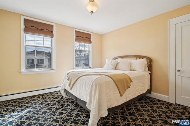 bedroom with a baseboard heating unit, carpet flooring, and baseboards