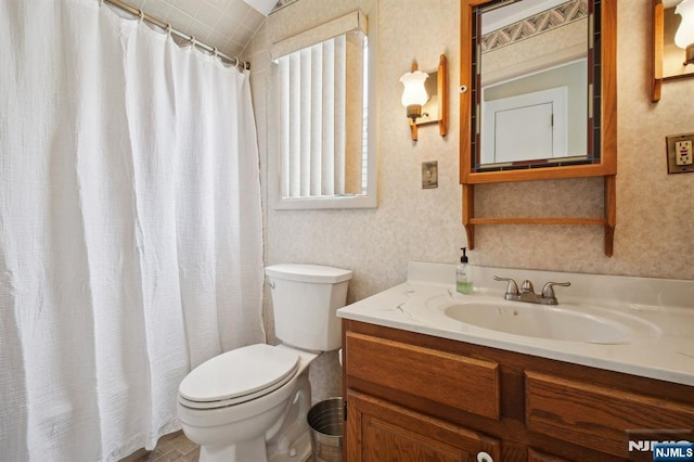 bathroom with curtained shower, vanity, toilet, and wallpapered walls