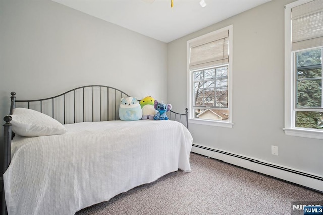 bedroom with multiple windows, baseboard heating, and carpet flooring