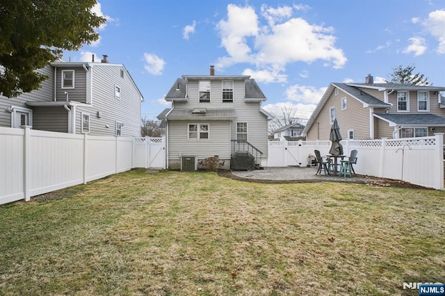 back of house with a patio area, a fenced backyard, a gate, and a yard