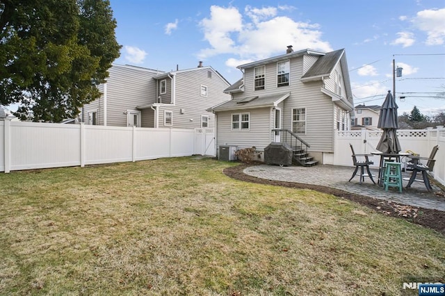 back of house with a patio, a fenced backyard, a chimney, a yard, and central air condition unit