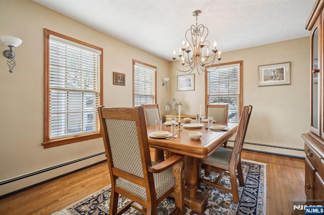 dining room featuring hardwood / wood-style flooring, baseboard heating, and a wealth of natural light