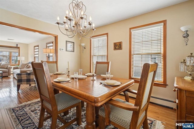 dining area with an inviting chandelier and light wood-style flooring