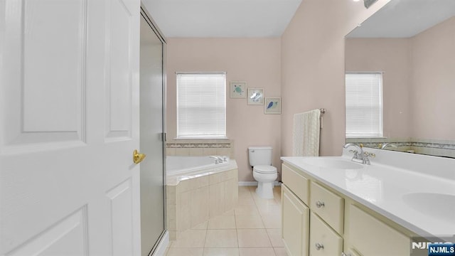 full bath featuring double vanity, tile patterned floors, toilet, a sink, and a bath