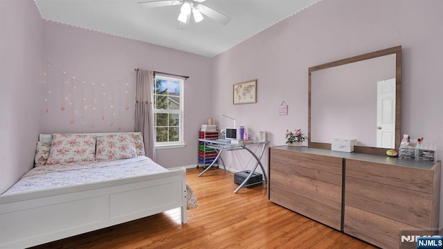 bedroom featuring ceiling fan, light wood-type flooring, and baseboards