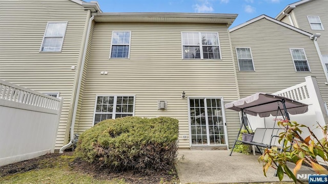 rear view of property featuring a patio area and fence