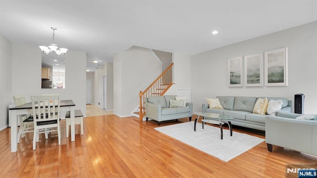 living room with a chandelier, stairway, light wood-type flooring, and recessed lighting