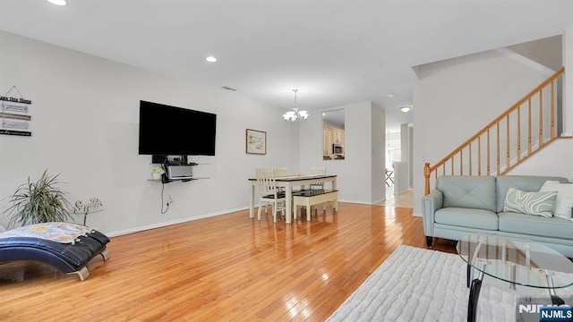 living area with a notable chandelier, recessed lighting, stairway, light wood-style floors, and baseboards