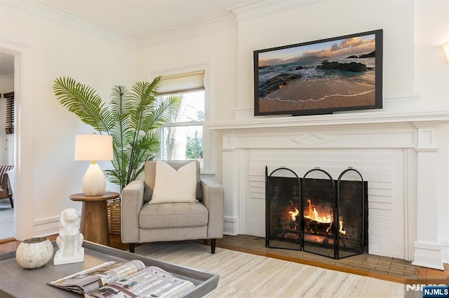 sitting room featuring ornamental molding, a brick fireplace, and wood finished floors