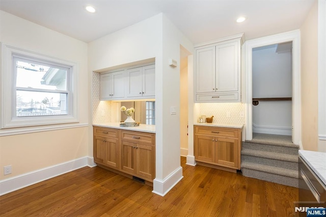 bar with baseboards, backsplash, and wood finished floors