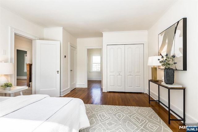 bedroom featuring dark wood-style floors, a closet, and baseboards