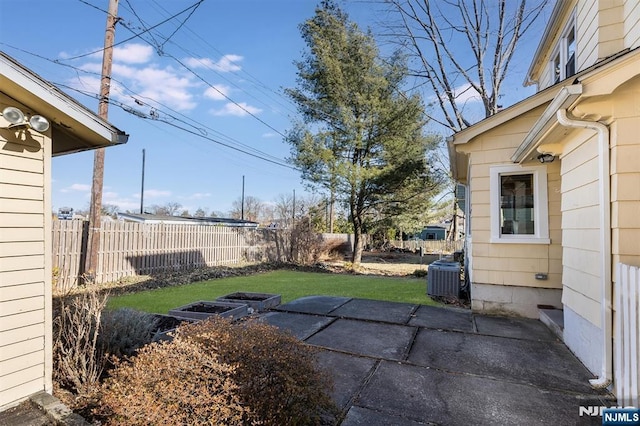 view of yard with a patio area, a fenced backyard, and central AC unit