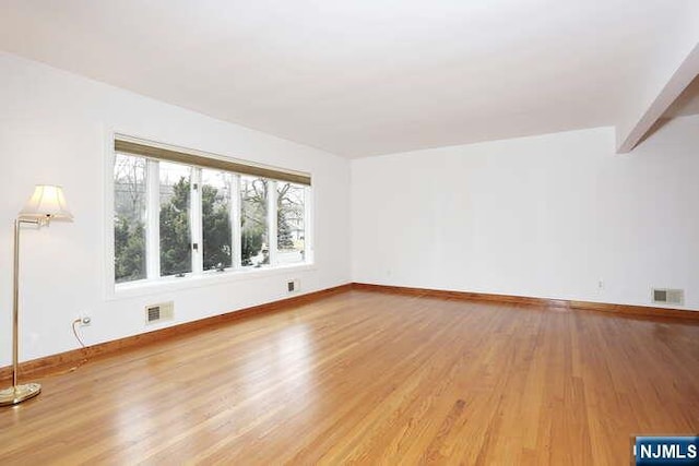 unfurnished living room featuring light wood-type flooring, baseboards, and visible vents