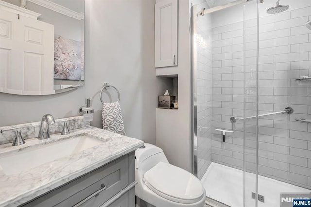 full bath featuring toilet, a shower stall, vanity, and crown molding